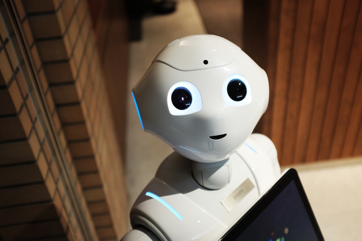 A humanoid assistant robot with a tablet, representing Machxel's AI products